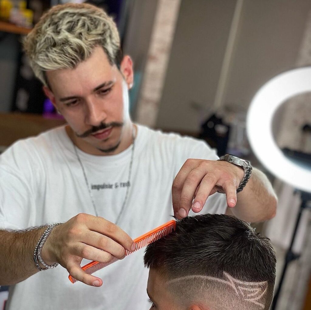 Barber using a hairdryer on a client during a grooming session in Luxembourg.